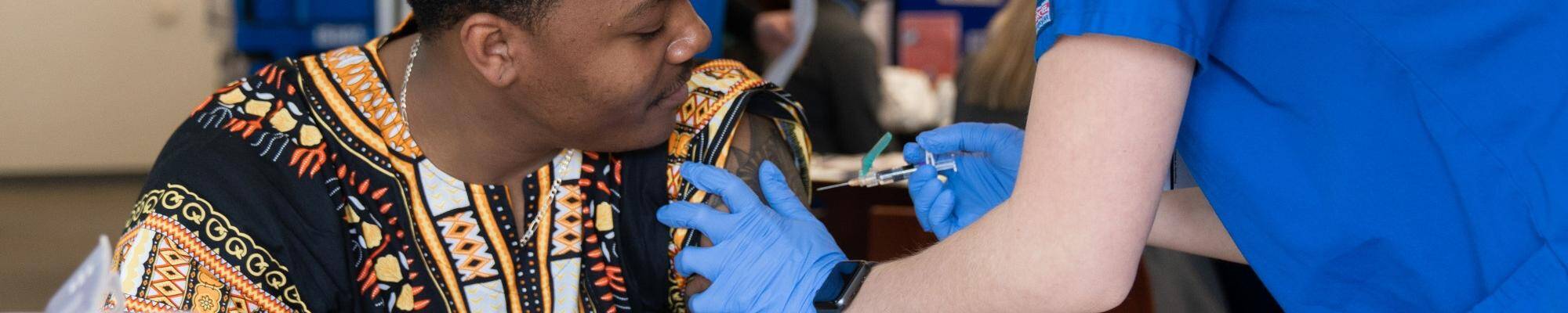 A physician gives a man an injection.